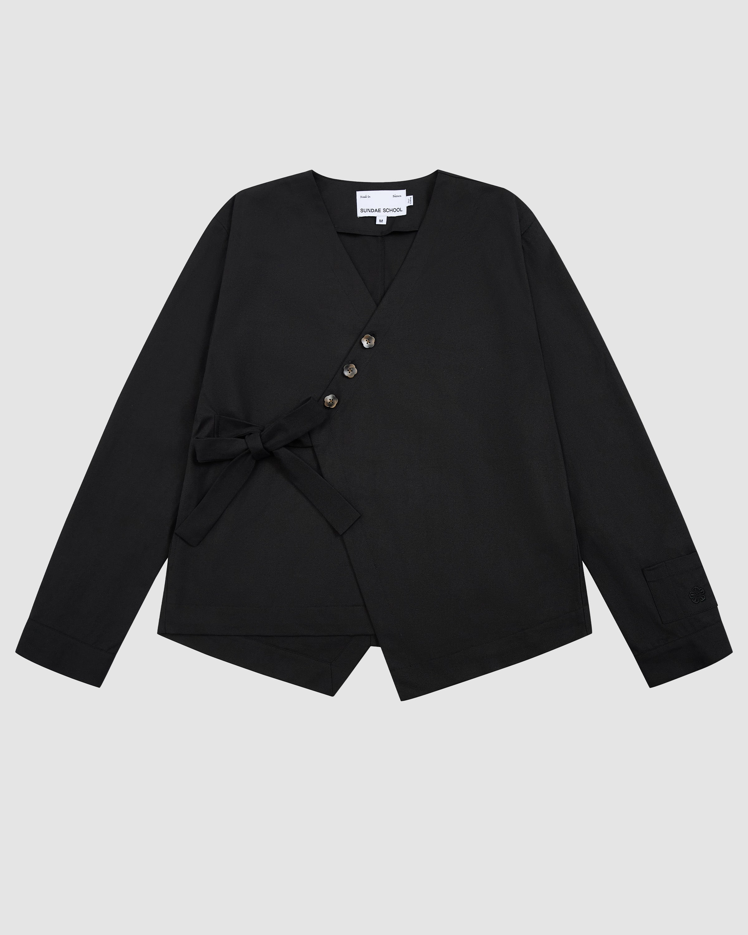 Black Hanbok Tie Blazer with V-neckline, three flower-shaped buttons, asymmetrical tie closure at the waist, and long sleeves.
