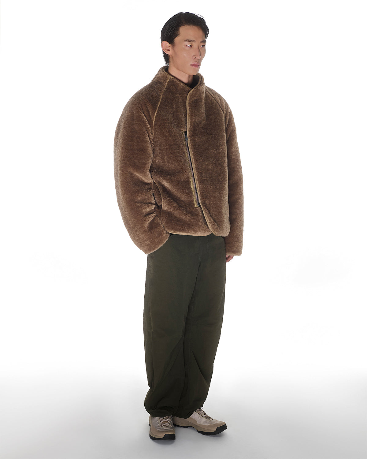 A man faces slightly right wearing the Sundae School [PRE-ORDER] REVERSIBLE FLOWER QUILTED JEOGORI FLEECE, paired with olive green pants and beige sneakers, set against a plain white background.