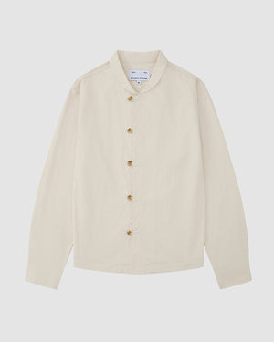 The Sundae School IVORY CHINA COLLAR KNOT SHACKET is a cream, long-sleeve relaxed layer with a mandarin collar and front buttons, made from corded cotton twill and shown laid flat on a light grey background.