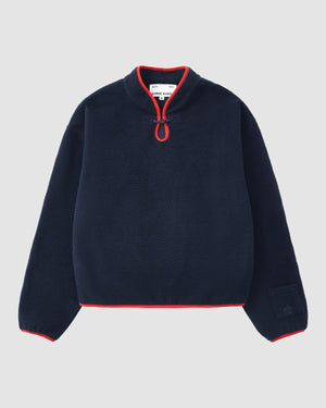 The NAVY TEARDROP KNOT FLEECE by Sundae School features a cozy navy fleece with long sleeves, a high collar, front half-zip with red trim, and red accents on the cuffs and hem.