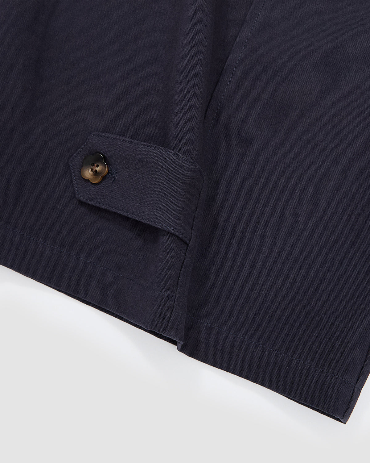 Close-up of the adjustable button tab at the hem of the Hanbok Balloon Pants with metallic flower-shaped button.