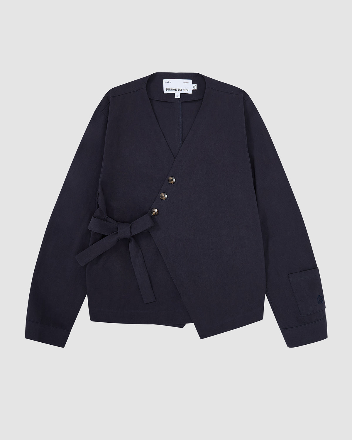 Navy blue Hanbok Tie Blazer with V-neckline, three flower-shaped buttons, asymmetrical tie closure at the waist, and long sleeves.
