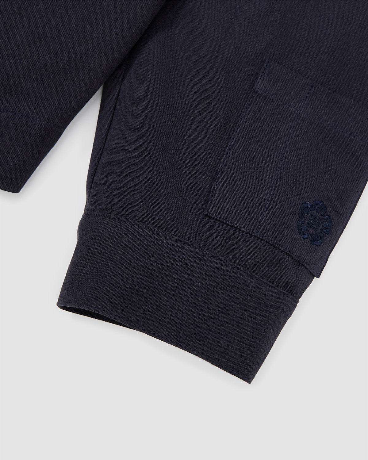 Close-up of the sleeve cuff of the Hanbok Tie Blazer showing embroidered logo detail and clean hemline.