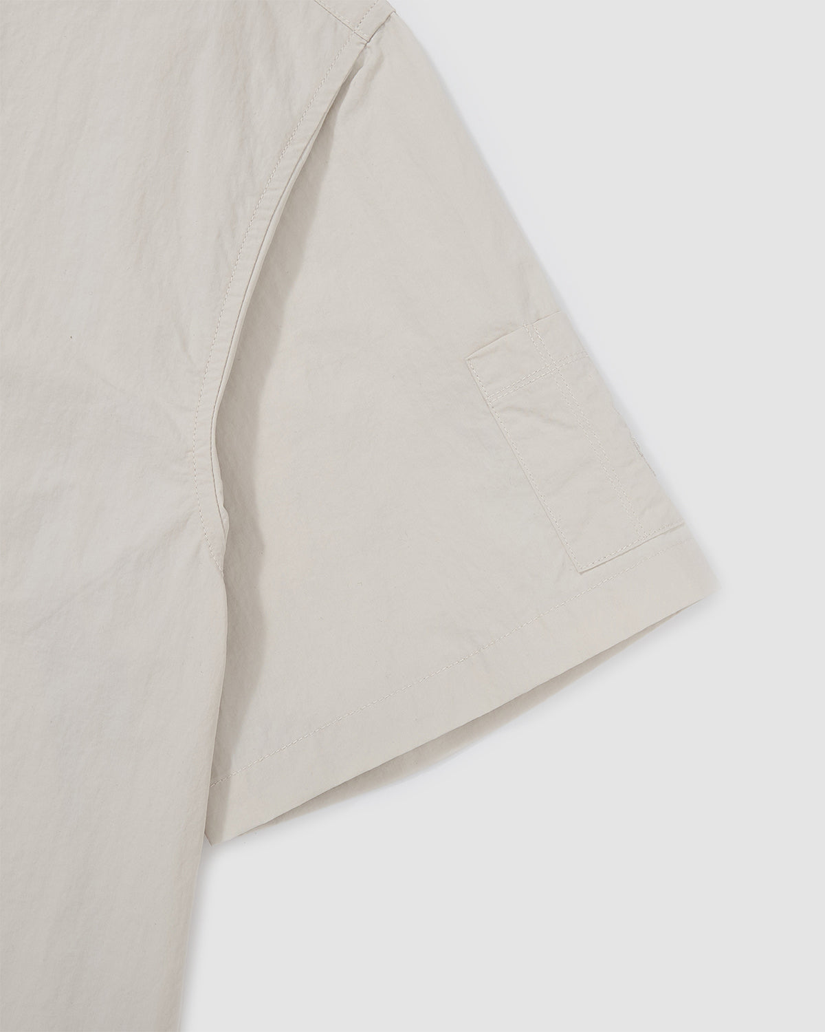 Detail of the chest pocket on the Ivory Yin Yang Short Sleeve Shirt showing embroidered logo accent.