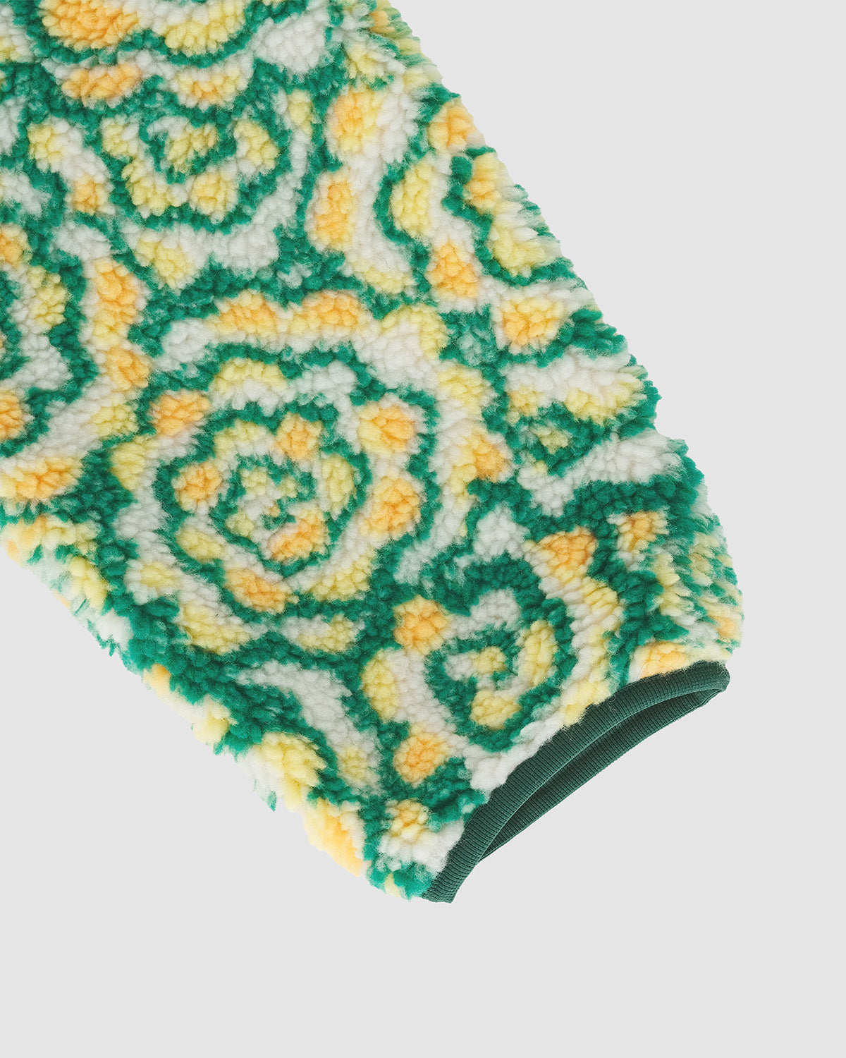 Sleeve of the Sundae School Broccoli fleece jacket featuring green and yellow floral patterned fleece, orange contrast collar and trim details, dark green zip closure, yellow chest pocket with zipper, relaxed fit silhouette, flat lay product shot on light background.