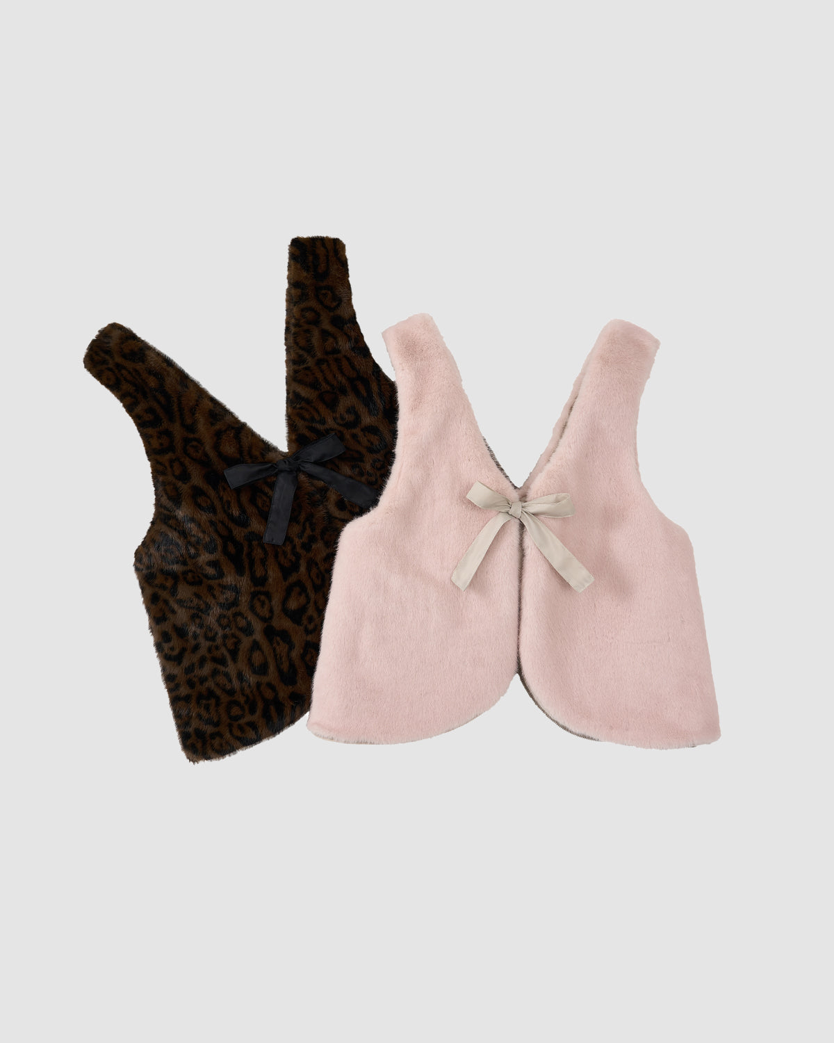Two sleeveless children’s vests by Sundae School are shown: a brown faux fur with black leopard print and bow, and the SILVER PINK BAEJA VEST / BAG in light pink with a beige bow. Both are soft, fuzzy, and displayed on a plain background.