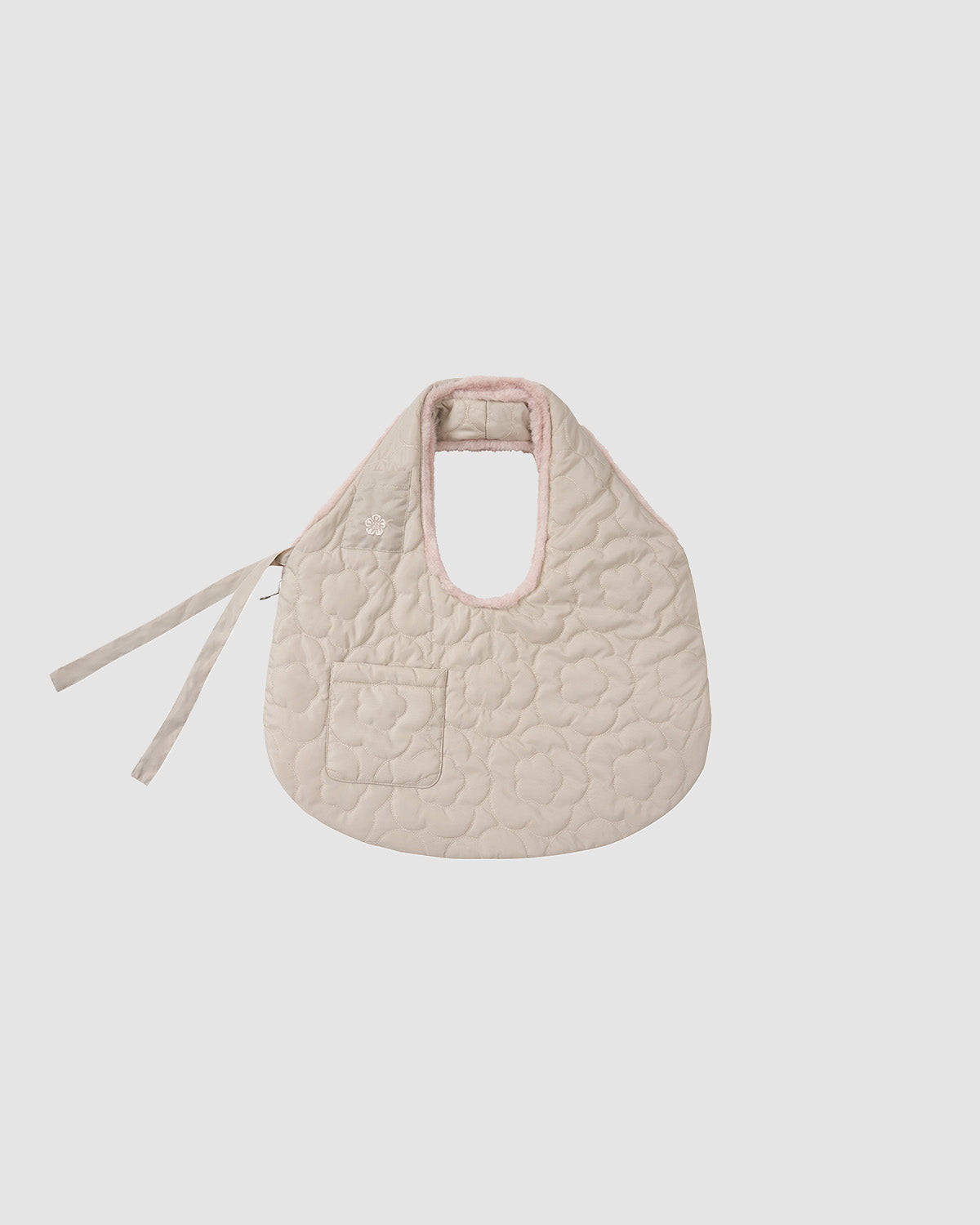 The SILVER PINK BAEJA VEST / BAG by Sundae School is a quilted, light beige bib inspired by the reversible baeja vest, with a small front pocket, pale pink trim, and two side ties, shown against a plain white background.