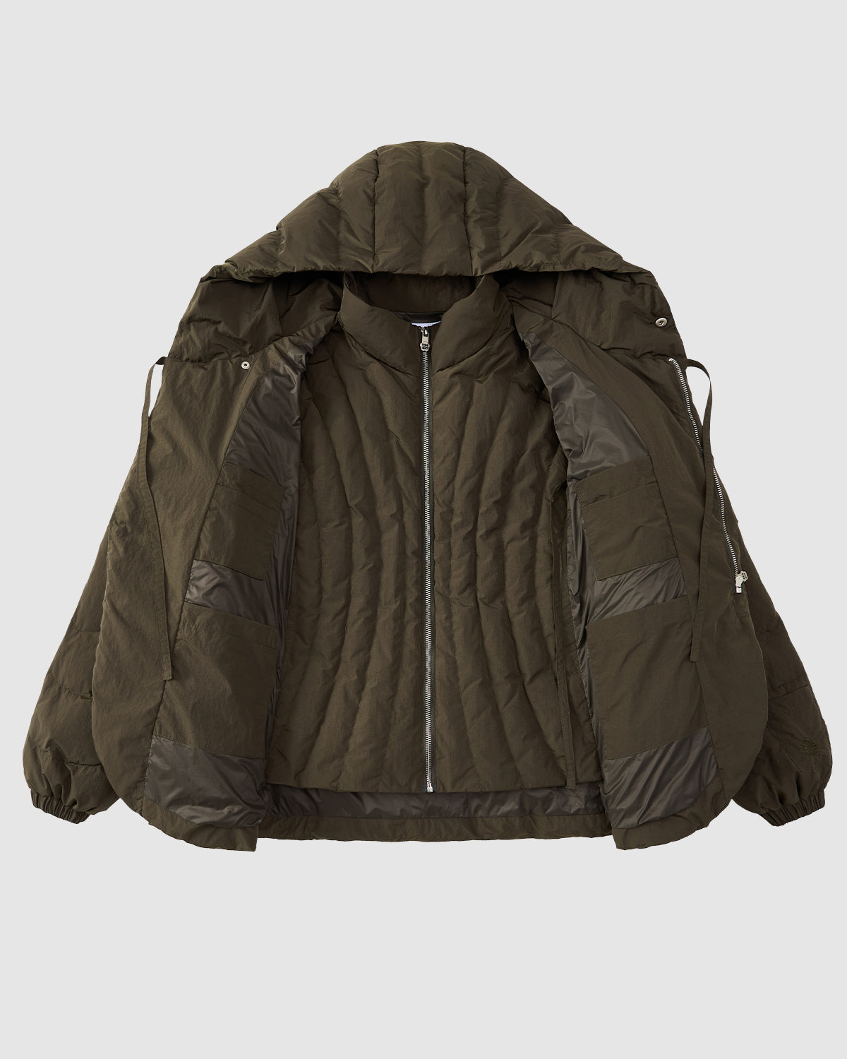 The Sundae School KHAKI HEAVYWEIGHT MOCHI PUFFER is shown unzipped on a light gray background, highlighting its quilted interior and inner pockets.