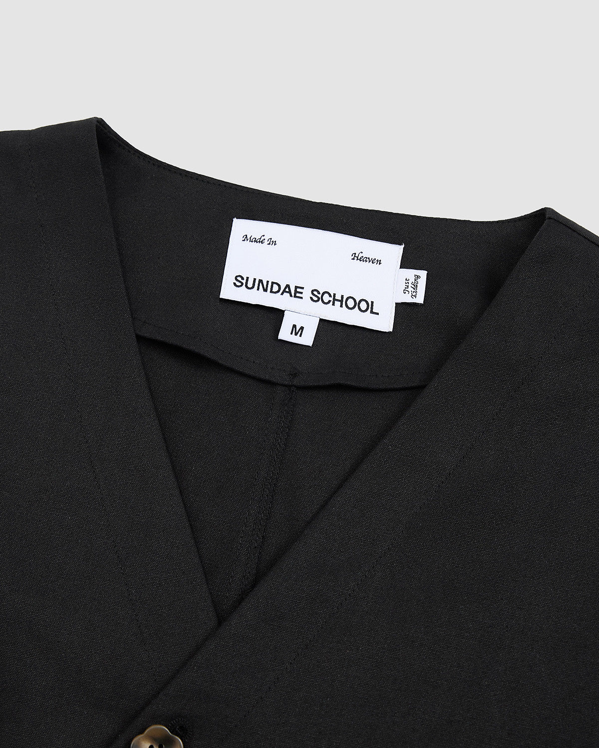 Close-up of the collar area of the Hanbok Tie Blazer showing the Sundae School brand label and V-neckline construction.