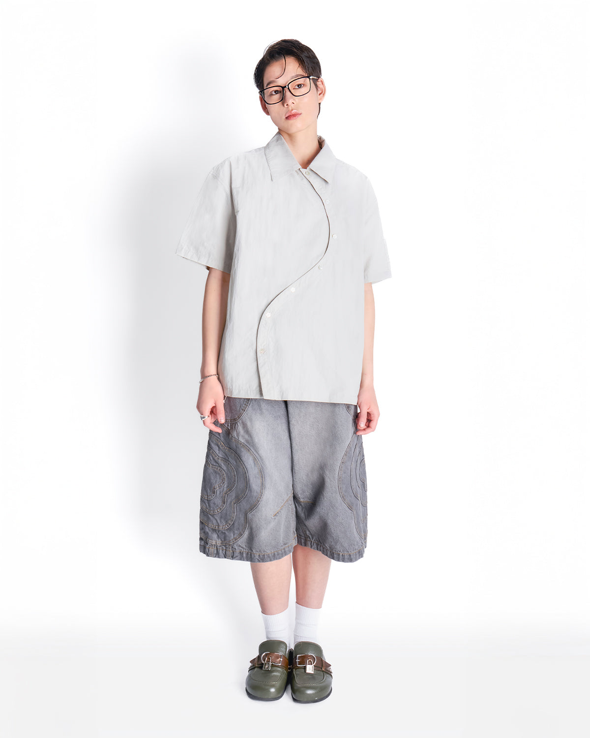 Model wearing the light gray Gray Yin Yang Short Sleeve Shirt with glasses, styled with gray patterned shorts, white socks, and brown leather loafers.