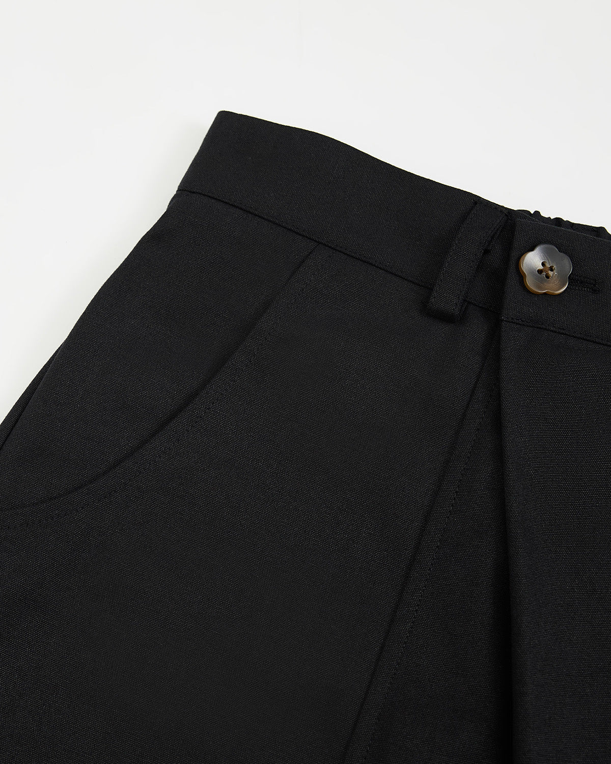 Detail view of the waistband construction showing contrast stitching and adjustable button closure system.