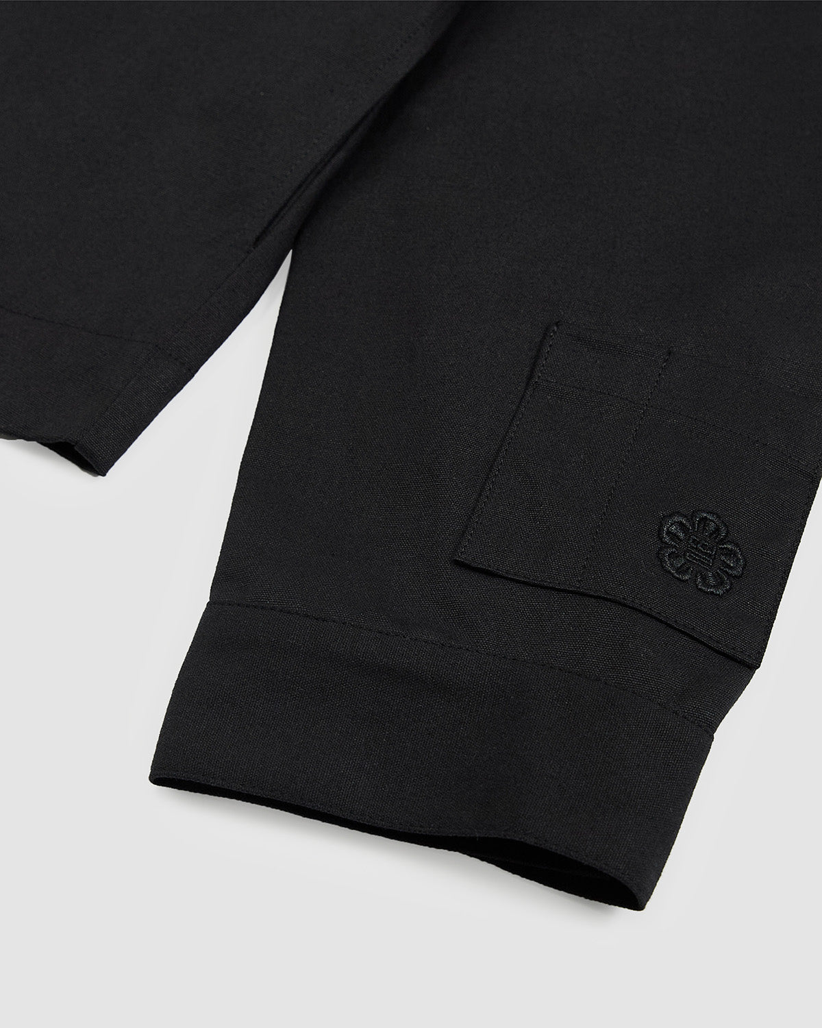 Close-up of the sleeve cuff of the Hanbok Tie Blazer showing embroidered logo detail and clean hemline.