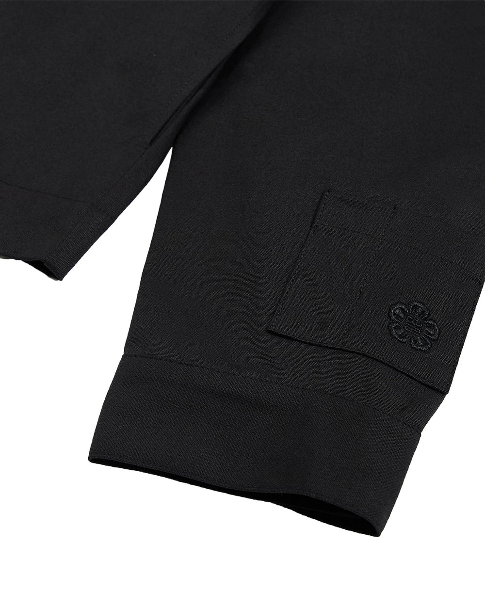 Close-up of the BLACK HANBOK TIE BLAZER by Sundae School, featuring a cuffed hem and a small pocket with an embroidered flower design, inspired by the elegant lines of a jeogori silhouette.