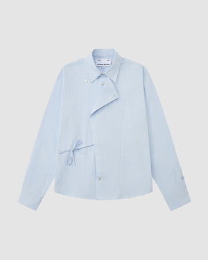 Sundae School SKY BLUE TIE GORUM SHIRT: light blue seersucker cotton, long sleeves, collar, asymmetric buttoned flap with gorum tie, single chest pocket, and buttoned cuffs. Shown on a plain white background.