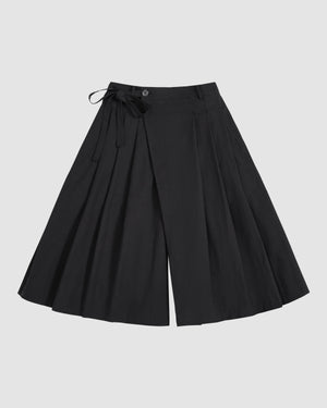 BLACK PLEATED HANBOK CULOTTES by Sundae School, featuring wide legs, pleats, a button closure, and a matching fabric tie at the waist, are displayed laid flat on a light gray background.