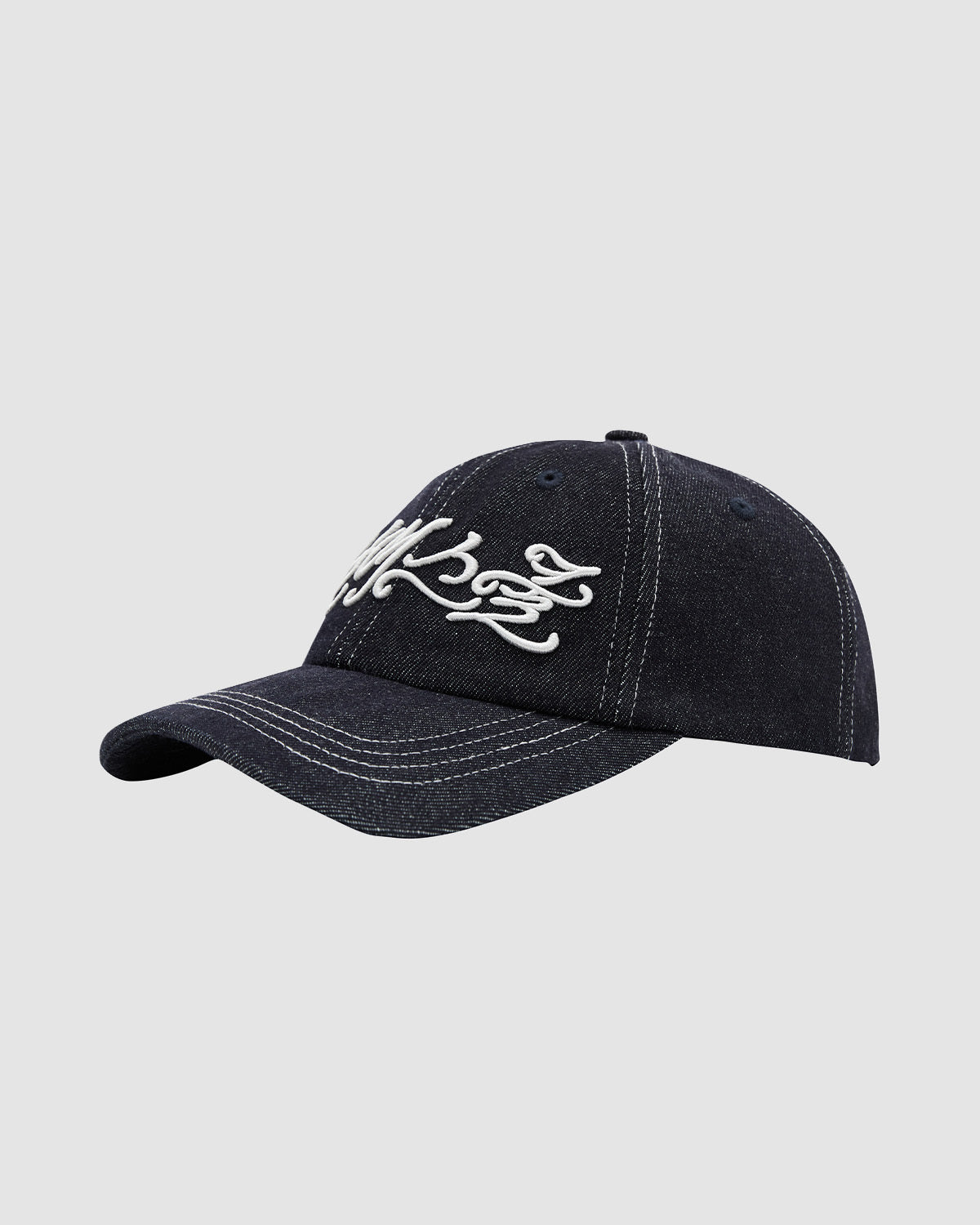 The Sundae School INDIGO DAENGGI CAP is a dark denim 6-panel adjustable cap with white stitching and front decorative embroidery, shown on a plain light gray background.