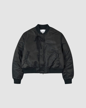 The BLACK FLOWER CHANNELED BOMBER by Sundae School features ribbed cuffs, collar, and hem, a front zip closure, side pockets, and a tie detail near the collar, shown against a plain light gray background.