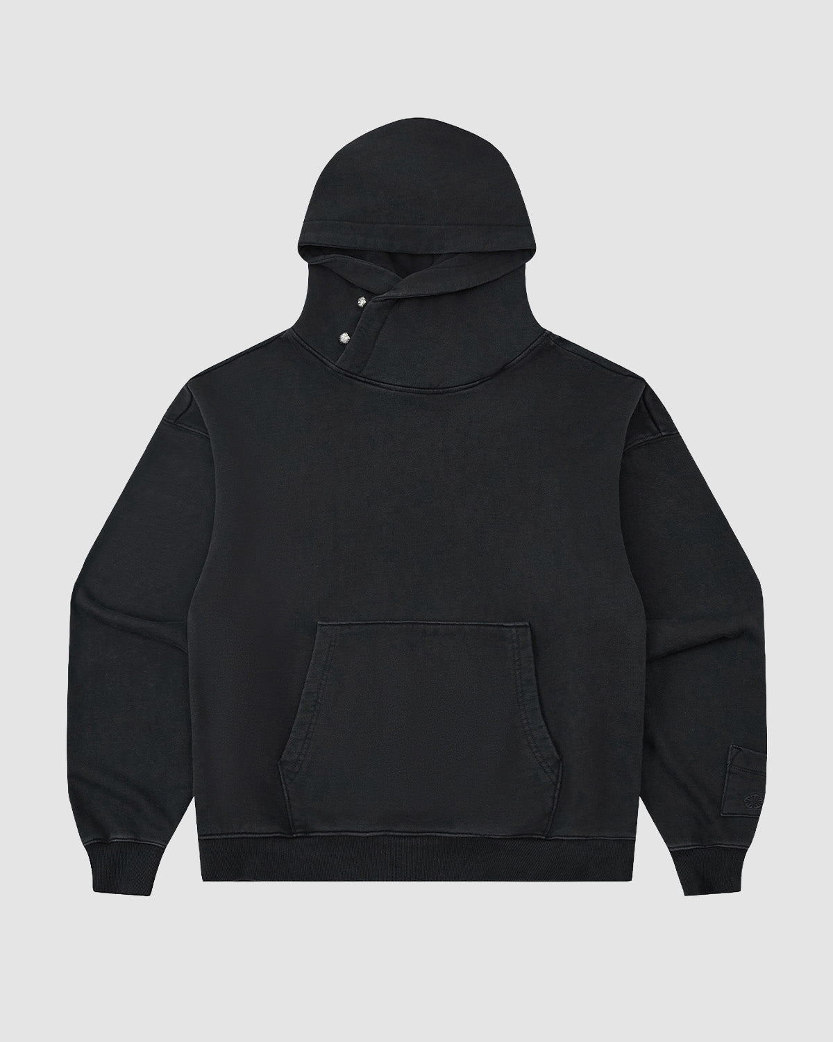 The Sundae School FADE BLACK COCOON HOODIE is a limited edition black sweatshirt featuring an oversized hood, front kangaroo pocket, and snap-button neck closure, shown on a plain light gray background.