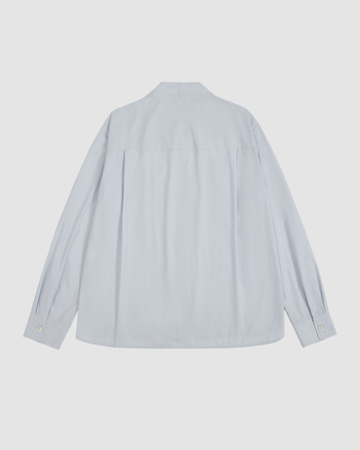The DART COLLAR SHIRT by Sundae School is displayed from the back in a light blue color, featuring a collar, cuffed long sleeves, and buttons visible on the cuffs.