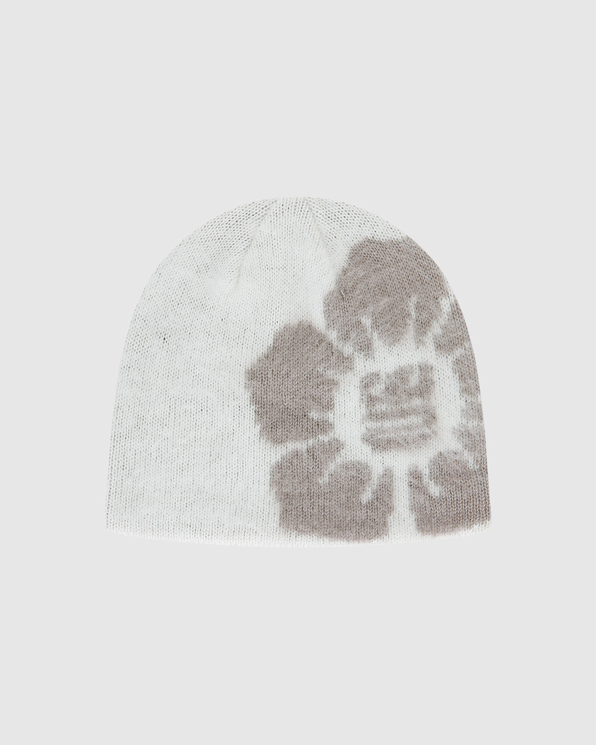 The Ivory Ddul Beanie by Sundae School is a white acrylic hat featuring a bold gray abstract flower on one side, combining stylish design with brain protection, shown on a plain light background.