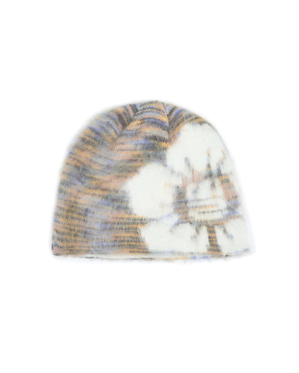 The Sundae School SEOUL HAZE DDUL BEANIE is a fuzzy knit, relaxed fit beanie featuring a blurred abstract landscape pattern in cream, tan, gray, and blue tones, finished with subtle blurry logo embroidery for a modern accent.