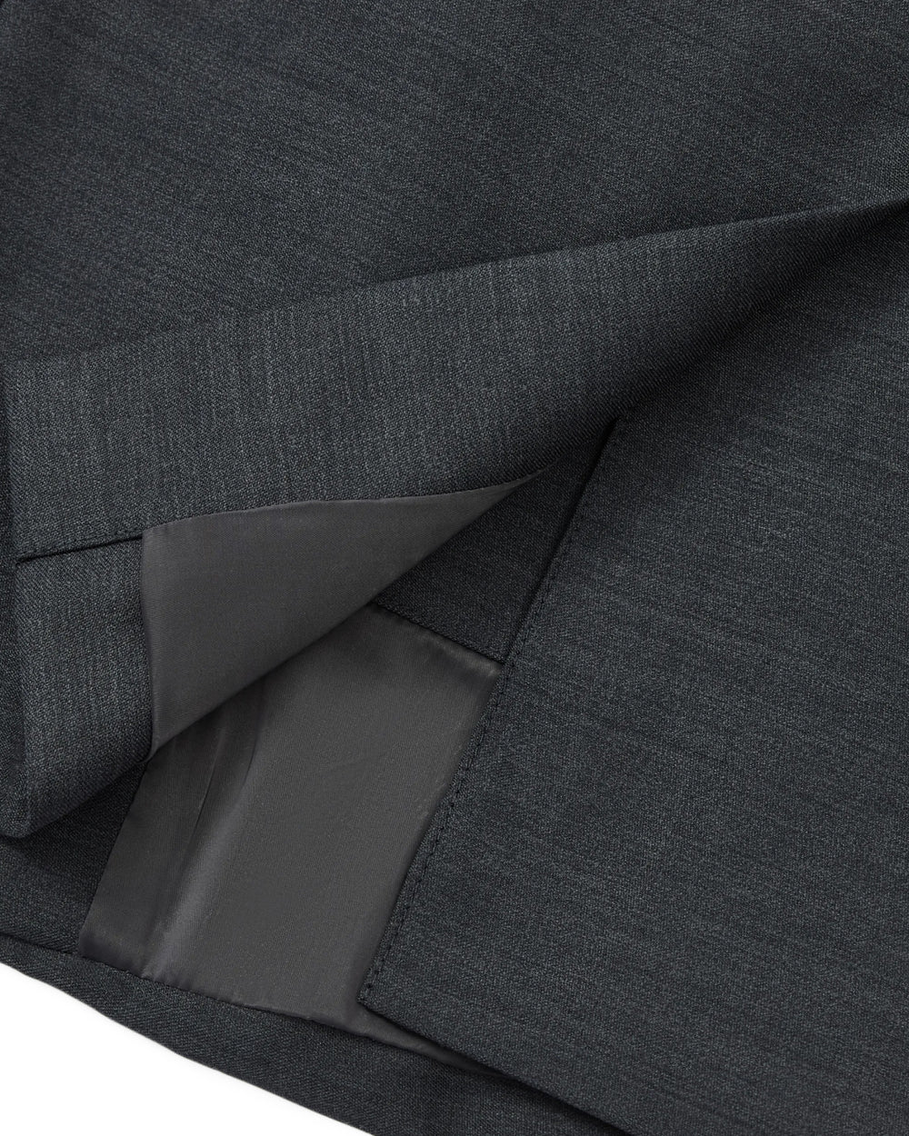 Close-up of the hem and inner lining of the CHARCOAL DOUBLE DUTY BLAZER by Sundae School, highlighting the neat stitching and smooth texture of its premium dark gray wool blend fabric.
