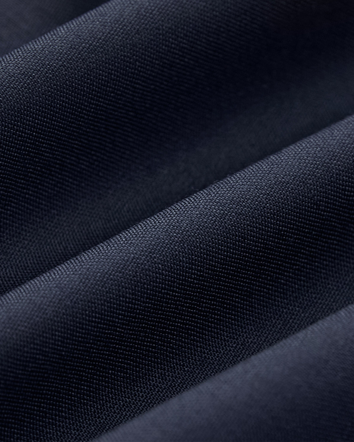 Close-up of Sundae School’s NAVY DOUBLE DUTY BLAZER fabric in dark blue, featuring a fine weave, soft folds, and a smooth, slightly shiny texture reminiscent of a wool blend blazer with graceful drape.