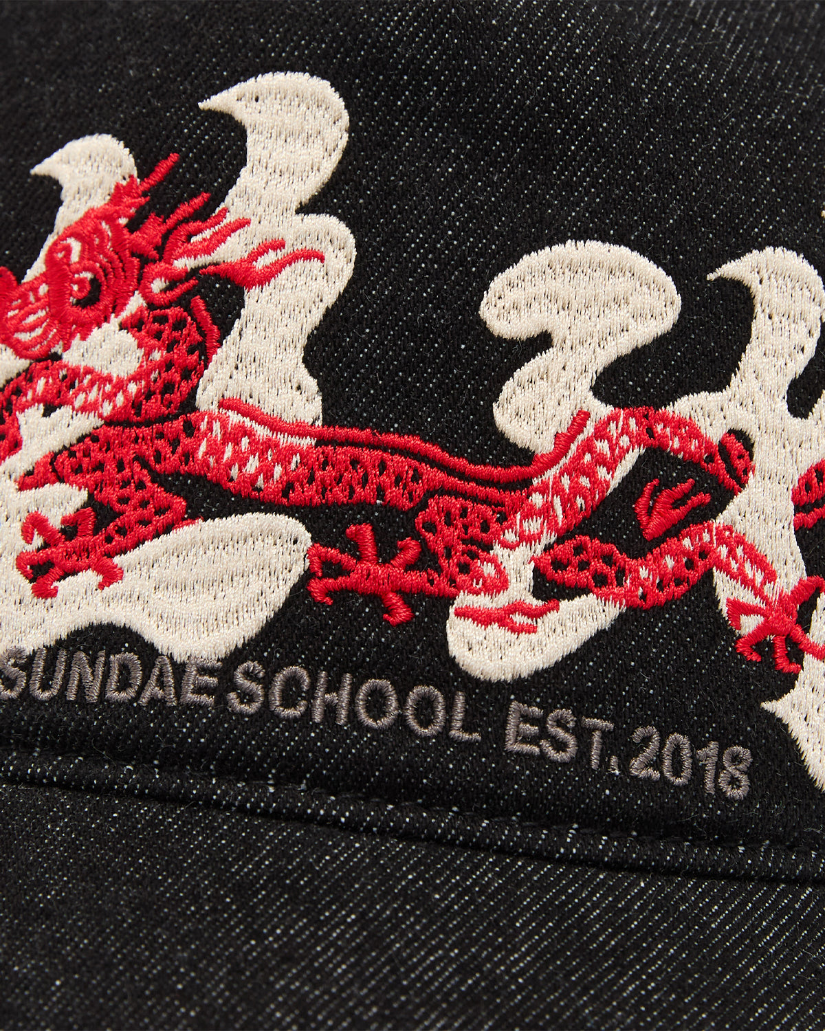 The BLACK DRAGON CAP by Sundae School features black fabric with an embroidered Korean dragon and white flames above gray text that reads SUNDALE SCHOOL EST. 2018.