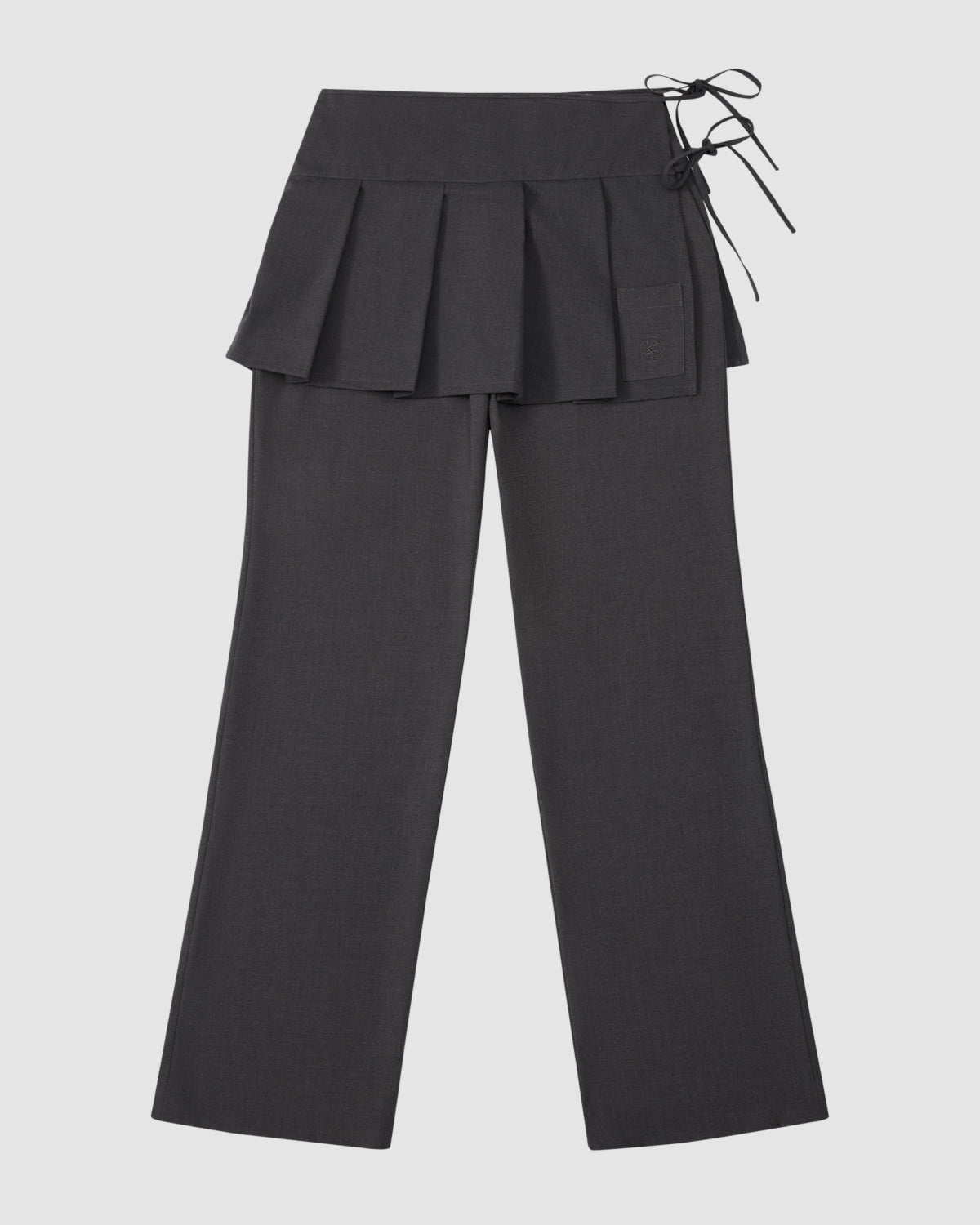 The Sundae School FLARE SKIRT PANTS are black tailored summer wool trousers with a wide waistband, removable pleated skirt overlay, and right side tie detail, shown on a light gray background.