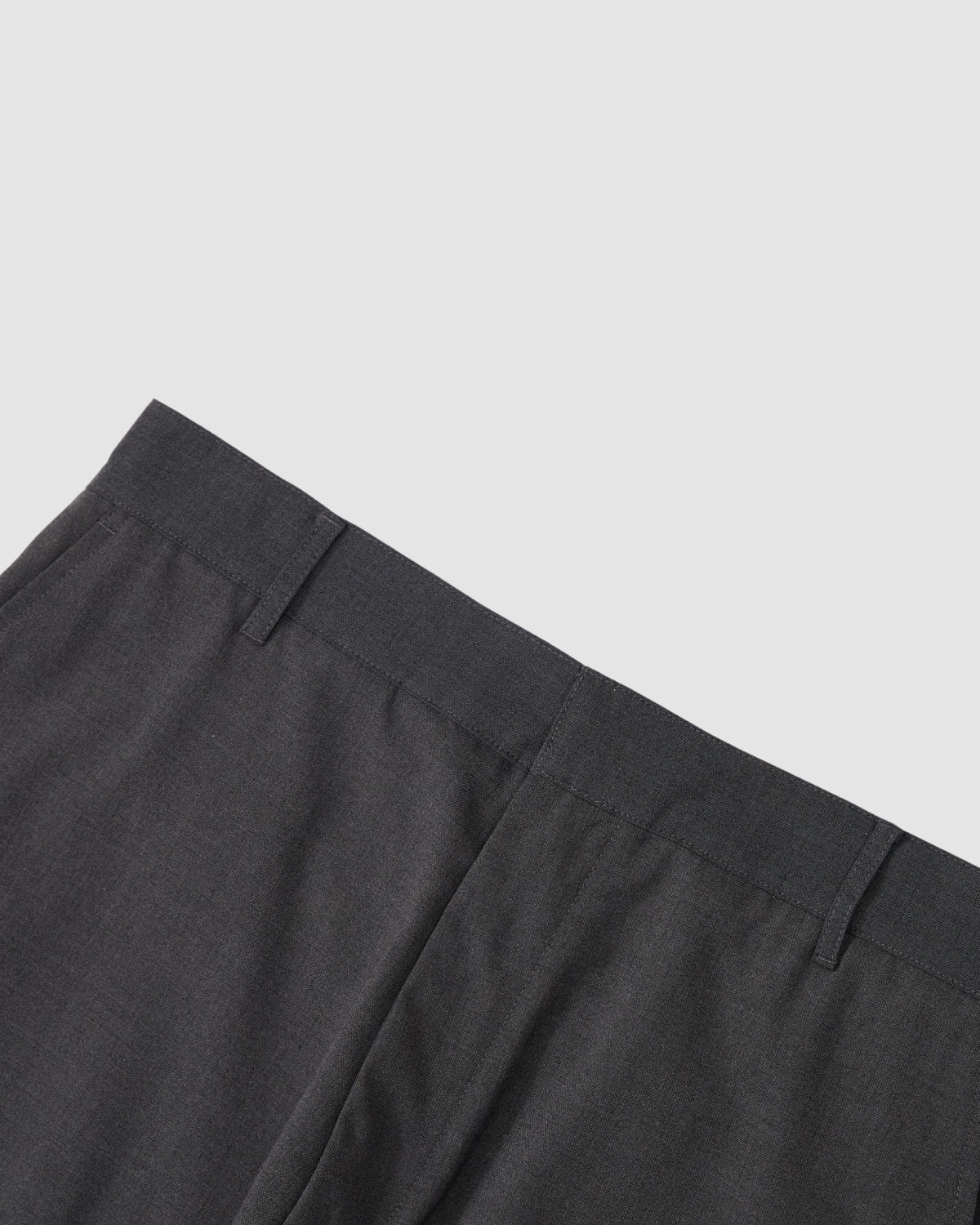 Close-up of the waistband and upper section of Sundae School's FLARE SKIRT PANTS in dark gray summer wool, featuring belt loops and side seams, set against a light gray background.