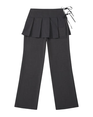 The FLARE SKIRT PANTS by Sundae School are crafted from dark gray wool tencel and feature a pleated apron skirt overlay at the waist with a side tie detail. These semi-bootcut trousers boast a straight-leg silhouette and include a small pocket on the skirt section for added functionality and style.