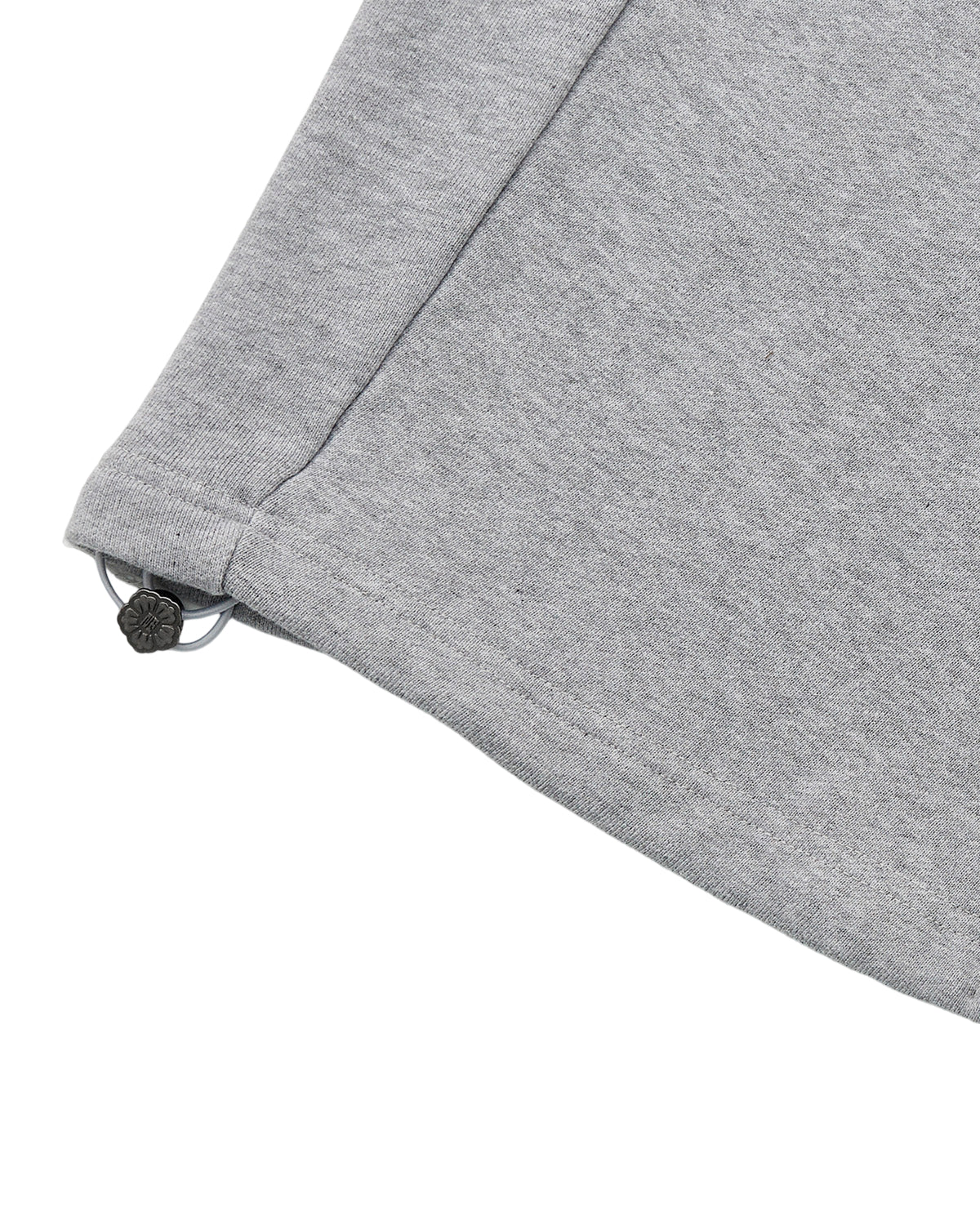 Close-up of the corner of Sundae School’s HEATHER GREY WRAP SWEATBAJI, a light gray fabric garment featuring an adjustable elastic drawstring with a plastic toggle at the hem, inspired by hanbok-style wrap sweatpants.