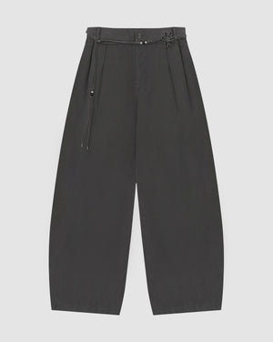 The CHARCOAL FLOWER NORIGAE LINEN TROUSERS by Sundae School are wide-leg black trousers inspired by Korean fashion, featuring a high waist, pleated front, and a thin belt with a knotted detail and small metallic accents, shown flat against a plain light background.