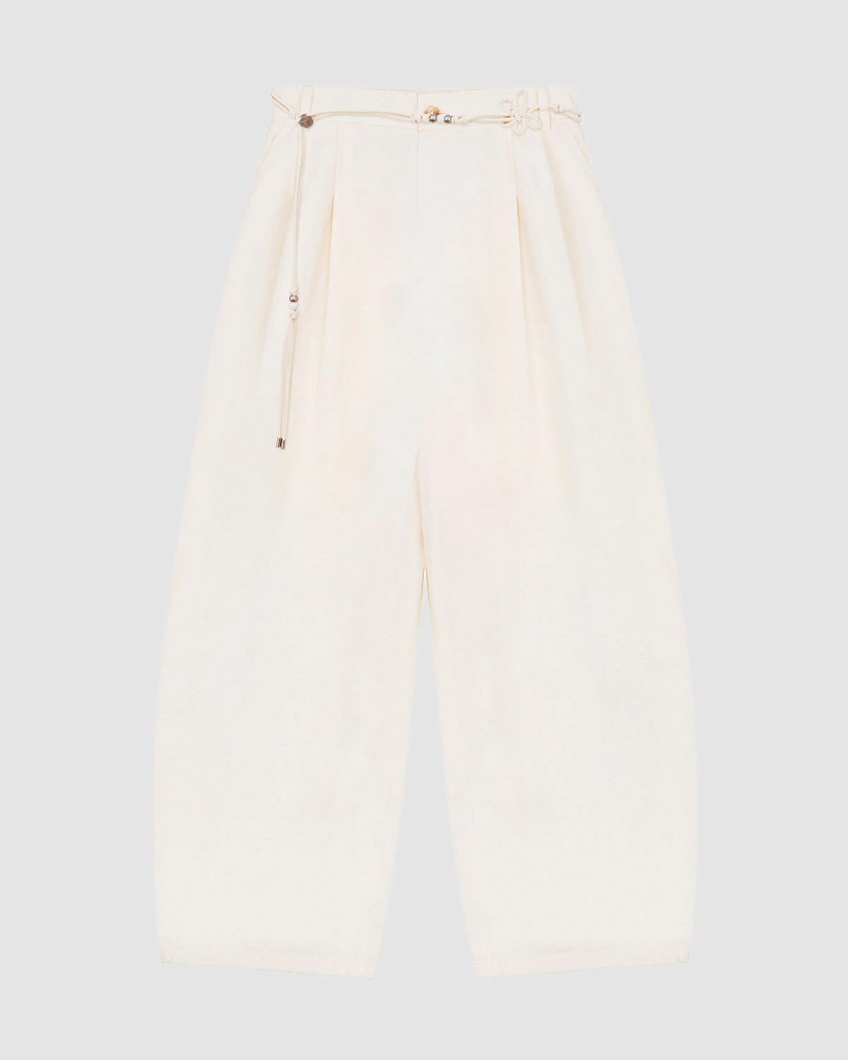 The IVORY FLOWER NORIGAE LINEN TROUSERS by Sundae School, featuring a wide-leg, high-waisted silhouette in cream cotton-linen with front pleats and an attached detachable norigae belt, are laid flat on a light gray background.