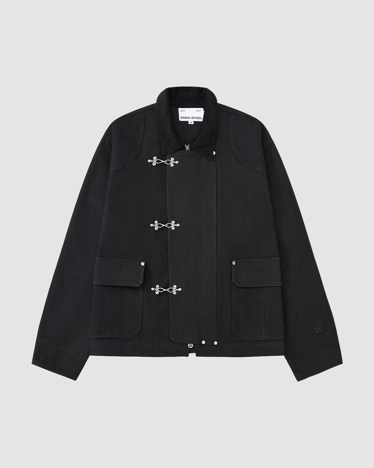 The [PRE-ORDER] BLACK FIREMAN CLASP JACKET by Sundae School is a vintage-style black cotton jacket with silver toggle clasps, two front flap pockets, collar, and visible seam details, shown on a plain light gray background.