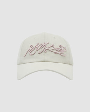 The Sundae School IVORY FLOWER KNOT CAP is a light beige cap with pink, cursive embroidery on the front, shown on a white background—ideal for bringing a vintage-inspired vibe to any outfit.