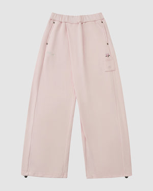 The Sundae School BABY PINK WRAP SWEATBAJI features a hanbok-inspired wide leg, elastic waistband, side and thigh pockets, adjustable hem drawstrings, and soft, comfortable fabric in a light pink hue.