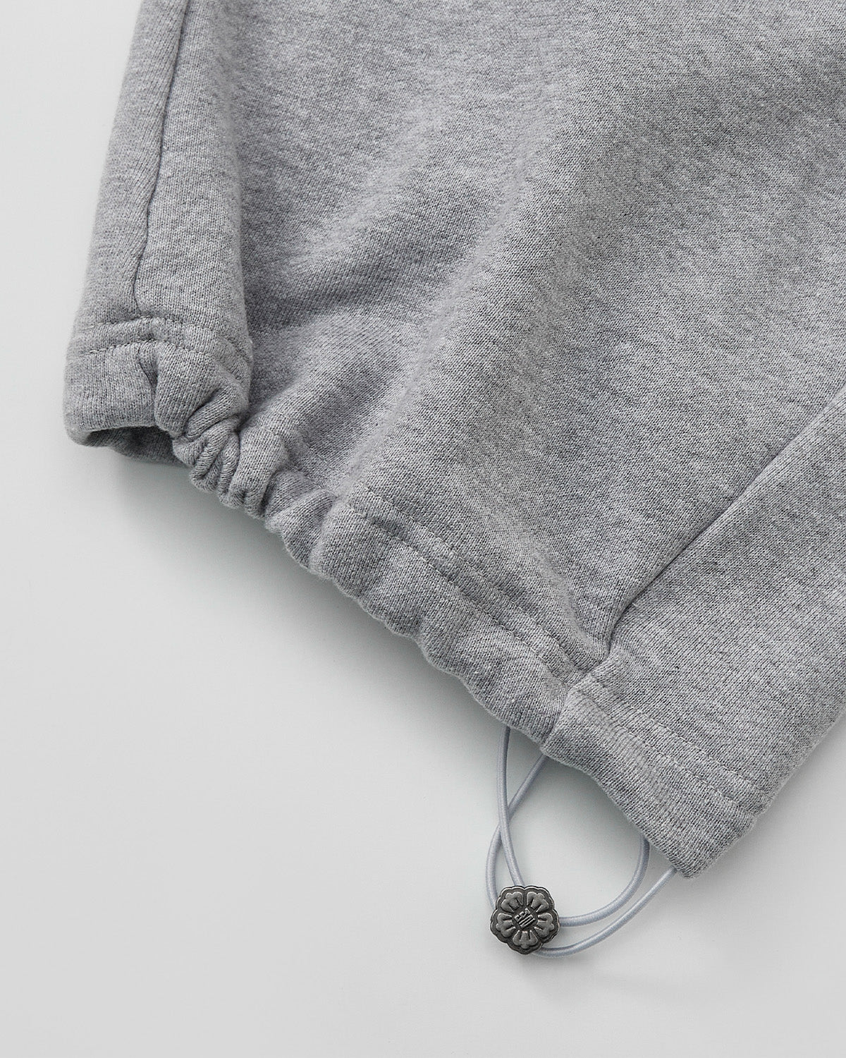 Close-up of the HEATHER GREY WRAP SWEATBAJI by Sundae School, featuring an elastic cuff and adjustable drawstring with a silver bead—ideal for pairing with unisex cotton pants or wide leg sweatpants for maximum comfort.