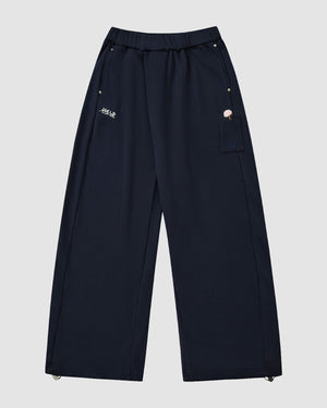 The Sundae School NAVY WRAP SWEATBAJI are loose-fit navy wide-leg sweatpants with an elastic waist, two front pockets, small embroidered accents by the right pocket and left thigh, plus adjustable drawstring hems.