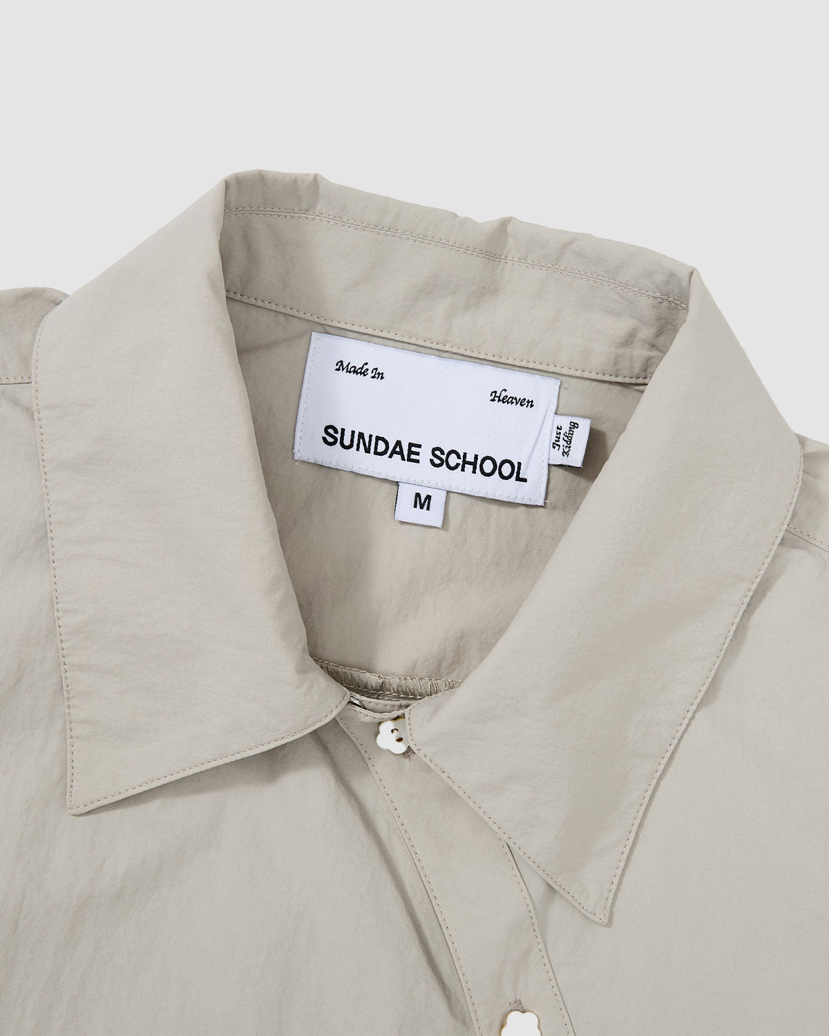 Close-up of the Gray Yin Yang Short Sleeve Shirt collar area showing the Sundae School brand label and asymmetrical button closure.