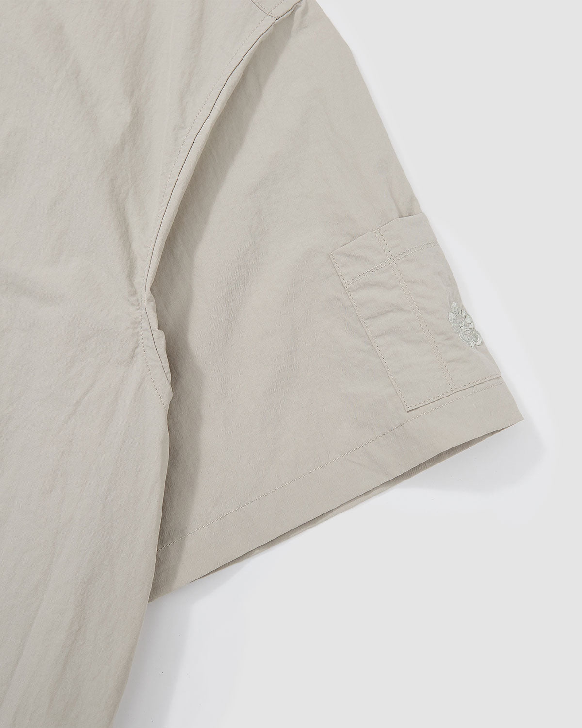 Detail view of the chest pocket on the Gray Yin Yang Short Sleeve Shirt showing embroidered logo accent.