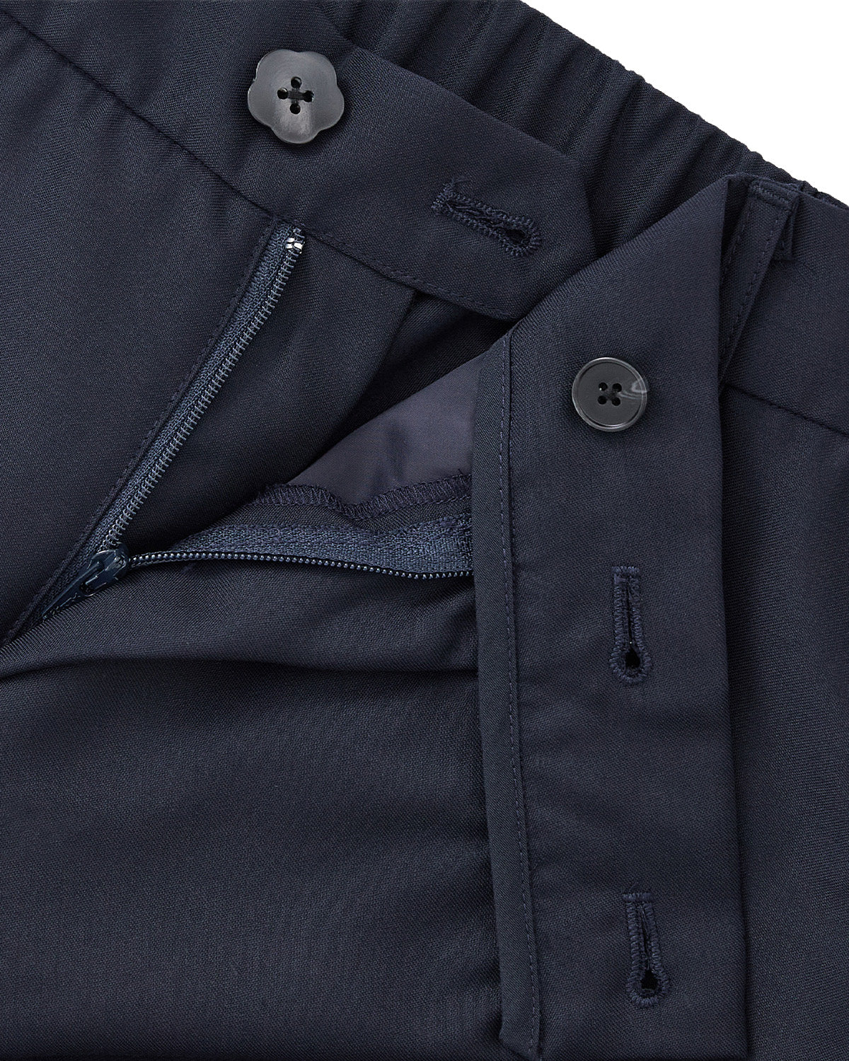 Close-up of Sundae School's NAVY PLEATED HANBOK SLACKS in navy blue wool blend. These unisex pants feature a partially open zipper, visible inner lining, button closure at the waistband, and an extra button on the tab above the zipper.