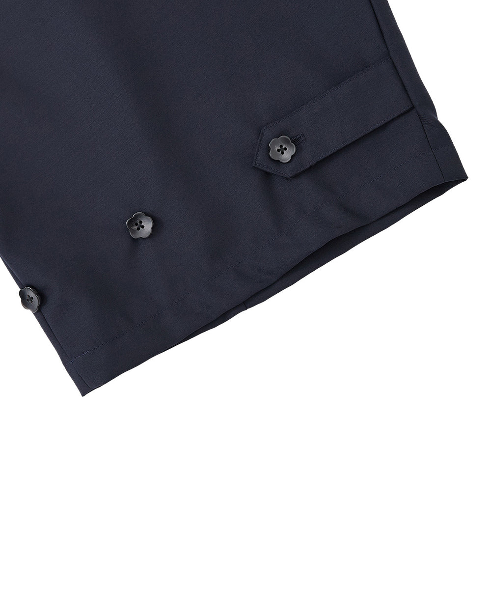 Close-up of the hem of Sundae School’s NAVY PLEATED HANBOK SLACKS, featuring three black buttons and a buttoned tab detail on navy blue wool blend, set against a light gray background.