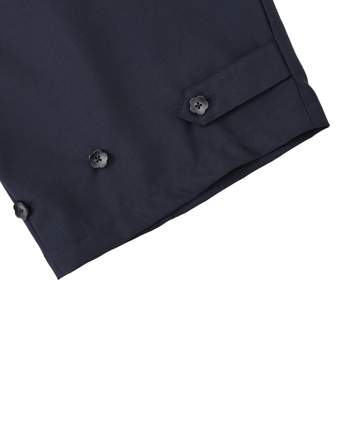 Close-up of the hem of Sundae School’s NAVY PLEATED HANBOK SLACKS, featuring three black buttons and a buttoned tab detail on navy blue wool blend, set against a light gray background.