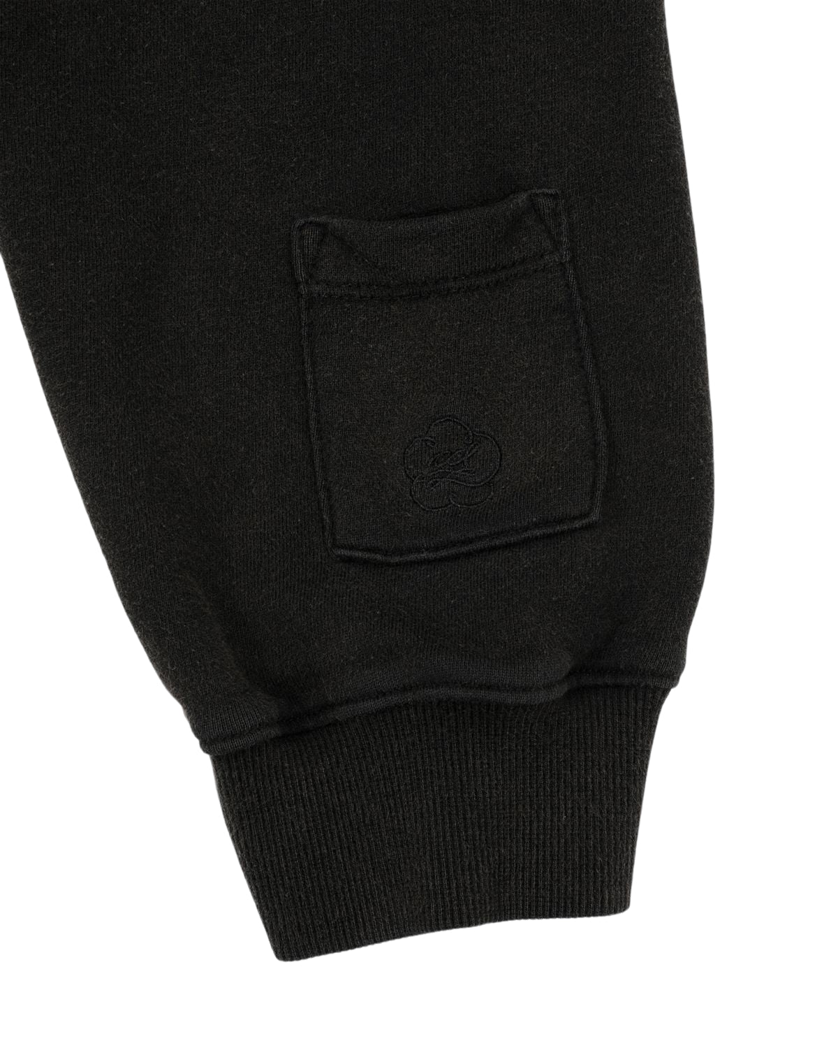Close-up of the BLACK WASH HANBOK HOODIE by Sundae School, showcasing a black cotton sleeve with a small patch pocket adorned with an embroidered cloud motif near the cuff. The soft fabric and ribbed wrist detail highlight the comfort and relaxed fit inspired by an oversized Hanbok Hoodie style.