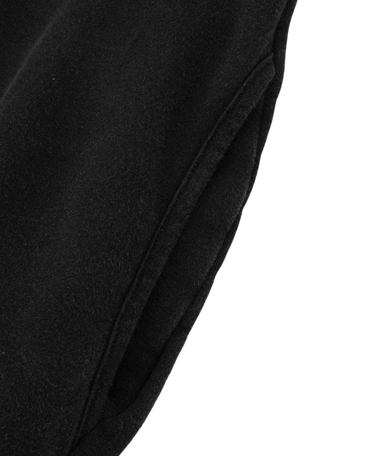 Close-up of the BLACK WASH HANBOK HOODIE by Sundae School, featuring black textured fabric with visible seaming and a pocket—evoking the feel of a classic cotton sweatshirt. The design nods to cozy oversized hoods, merging comfort with contemporary style.