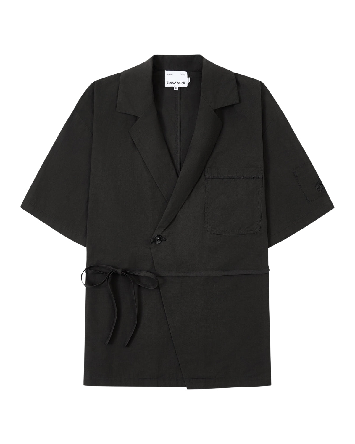 The BLACK HANBOK LINEN SHIRT by Sundae School is a black, short-sleeve blazer-style jacket inspired by the cotton linen hanbok, featuring a chest pocket, side tie closure, single button, and notched lapels, laid flat on a white background.