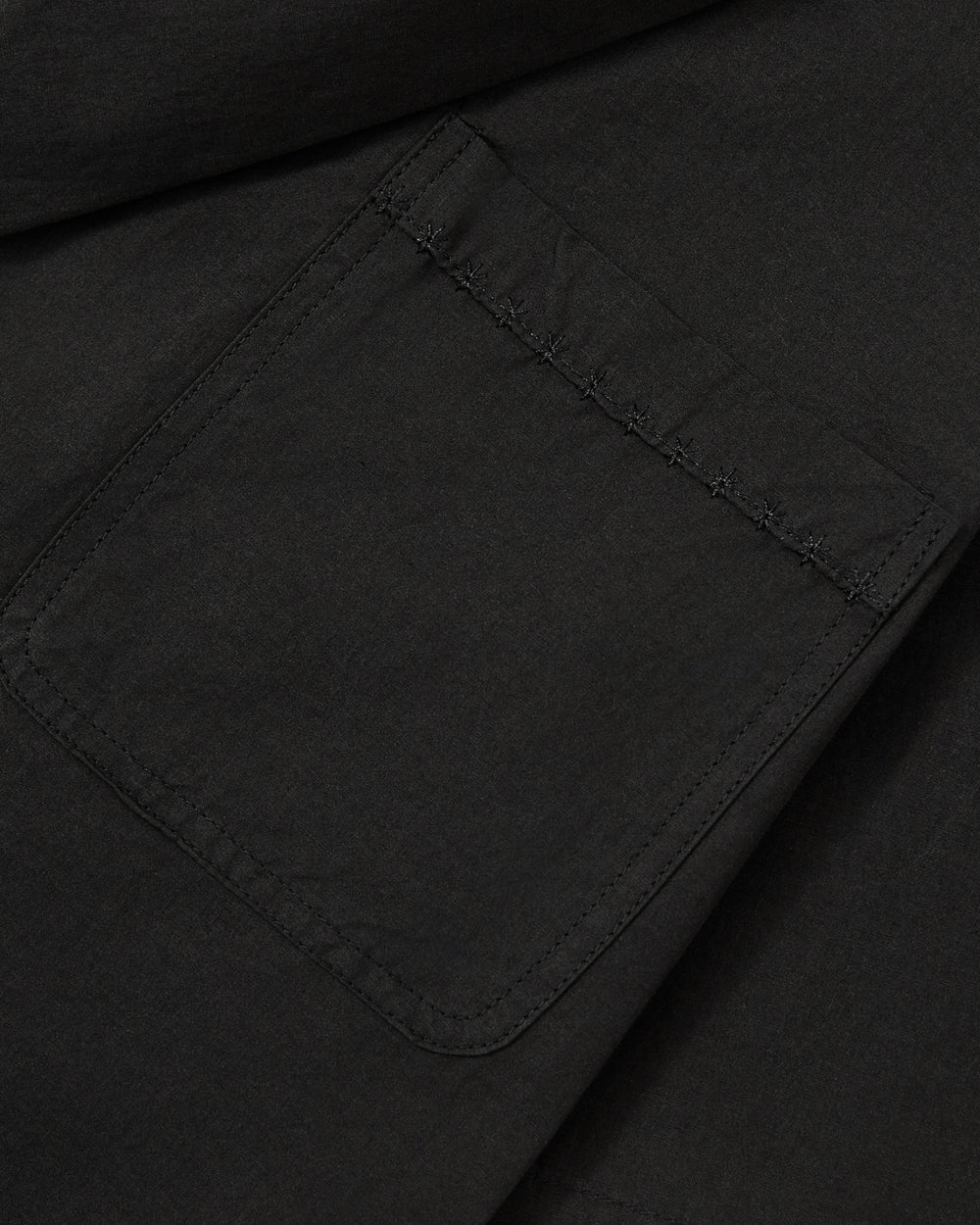 Close-up of the BLACK HANBOK LINEN SHIRT by Sundae School, featuring black fabric with a rectangular patch pocket and detailed stitching along the edges—ideal for adding modern style to your lightweight summer hanbok.
