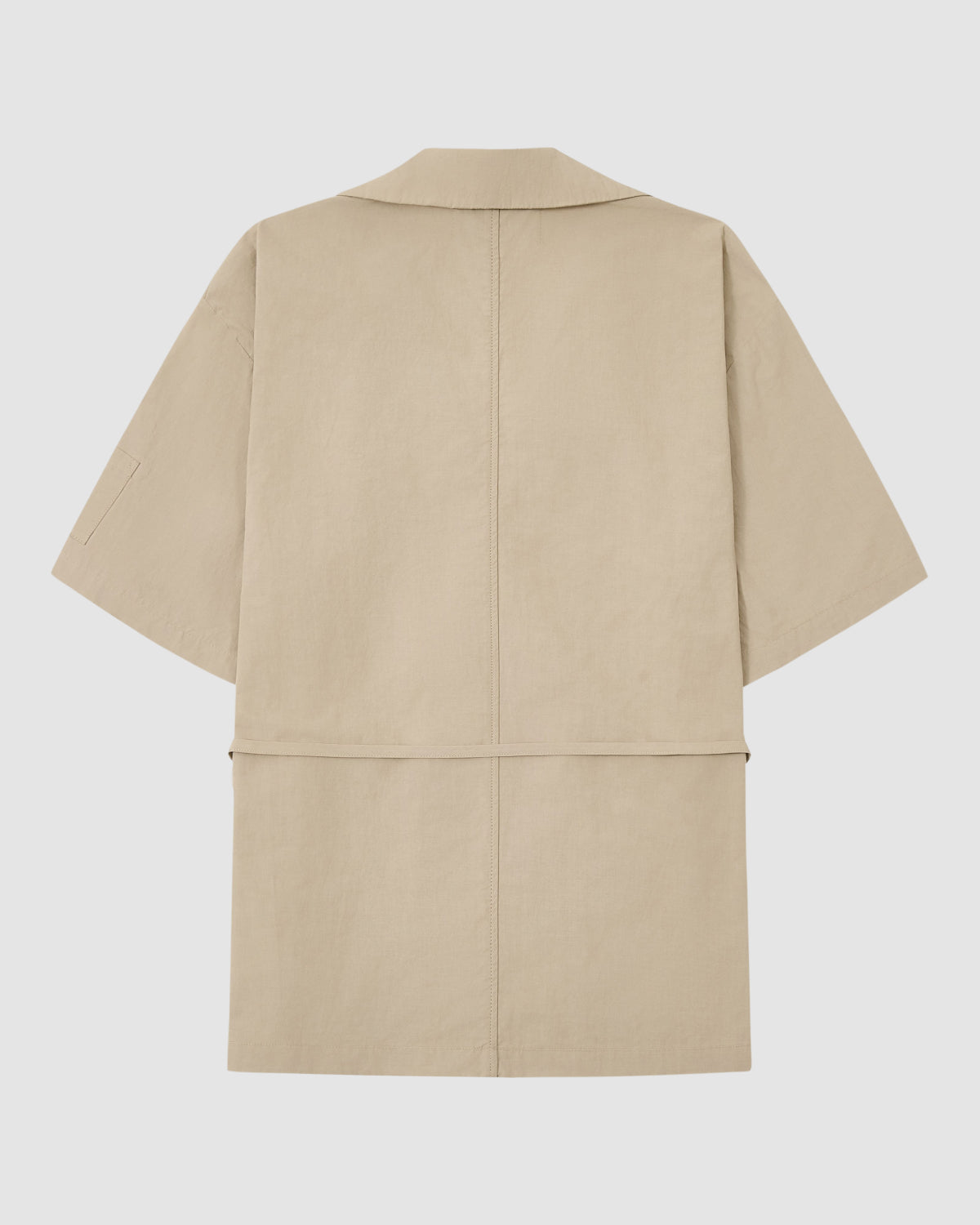 The Sundae School WHEAT HANBOK LINEN SHIRT is a beige, knee-length piece with short sleeves and a relaxed, boxy fit in a breathable cotton-linen blend. Minimal detailing and a straight hem are shown from the back against a plain white background.
