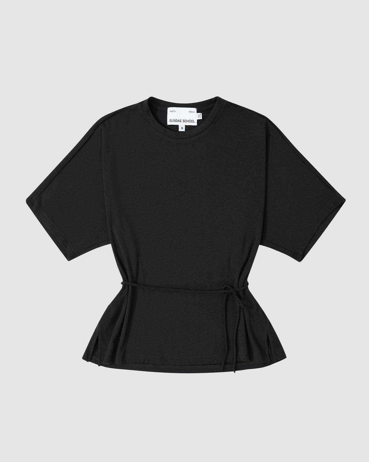 The BLACK BAERAE T-SHIRT by Sundae School is a black short-sleeve Hanbok-inspired tee with a round neckline and waist tie, shown laid flat on a light grey background.